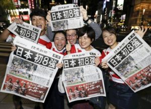  読売新聞の号外を掲げて、日本代表の躍進を喜ぶ人たち（東京・銀座で）