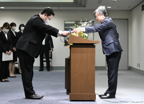  毎日新聞社の丸山昌宏社長から辞令を受け取る肥沼直寛さん（左）