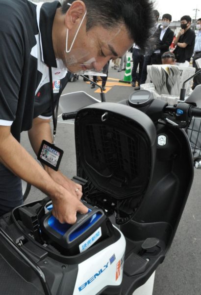  配達用のバイクにバッテリーを装着する読売新聞販売店のスタッフ（９月18日、京都市西京区で）