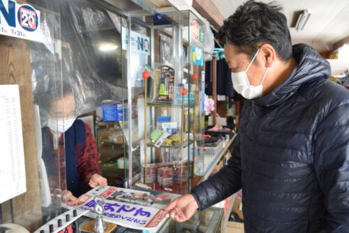  地元の商店街を一軒一軒歩き、号外の設置を依頼する岩手日報安代・田山センターの工藤悟所長（右）