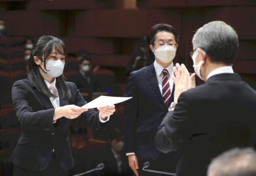  山口社長（右）から辞令を受け取る業務職・技術総合職代表の石井未羽さん（左）と、記者職代表の青野和正さん