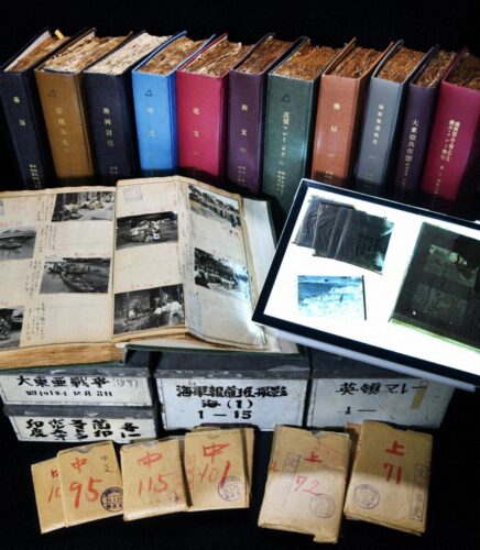  毎日新聞大阪本社に保管されている「毎日戦中写真」の一部。ネガは紙袋に入り、撮影地ごとにまとめてブリキ缶に収められている。６９冊のアルバムには写真説明や検閲記録などが書き込まれている