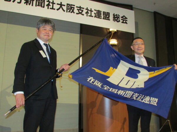  連盟旗の引き継ぎ式。海蔵氏（左）と笠井氏