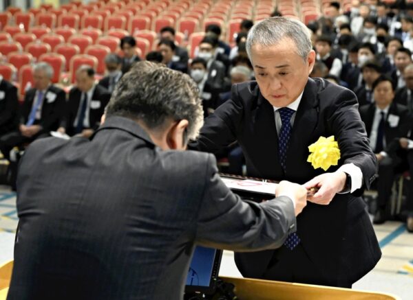  岩上販売局長（手前）から表彰状を受け取る鈴木所長