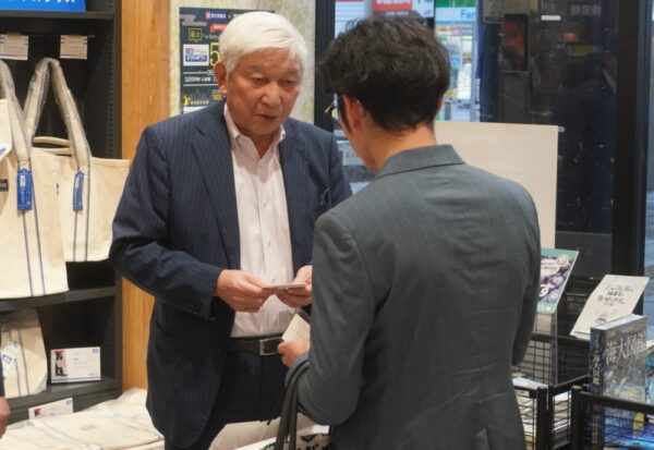  出版社とあいさつを交わす高井会長