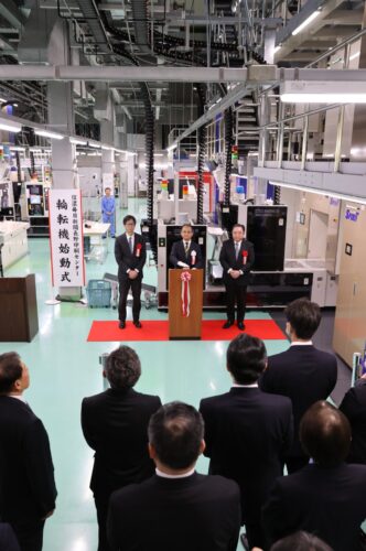  輪転機の始動式で、始動ボタンを押す信濃毎日新聞の小坂社長（奥中央）＝2026年2月5日、長野市