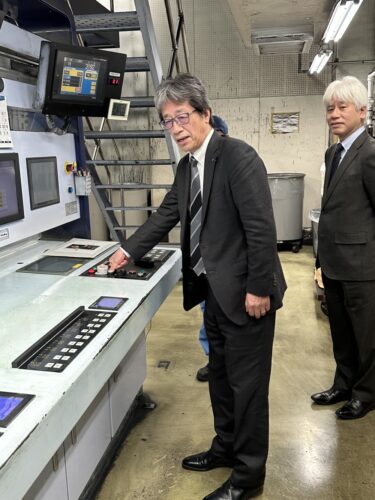  印刷開始のボタンを押す東奥日報社の田中社長