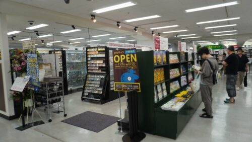  「まちキャラ」（左）の売場に隣接して、書店側はホビー関連書籍を展開