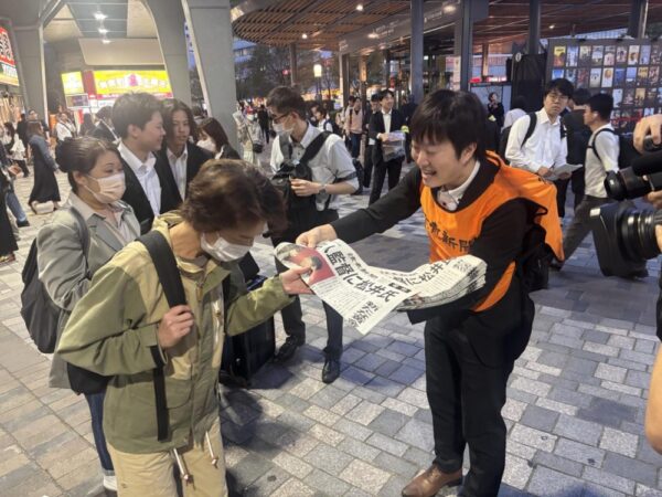  号外を受け取る人たち（東京・有楽町駅前で）